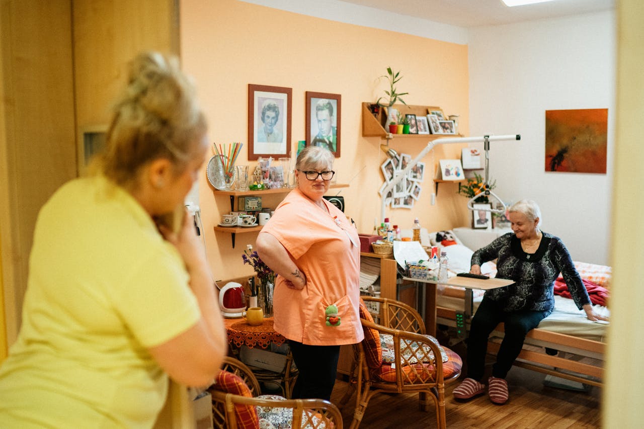 who-we-are Caregivers interacting with a senior woman in a cozy retirement home in Karviná, Czech Republic.