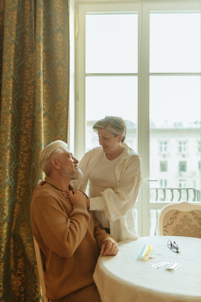services-02 Warm and affectionate scene of an elderly couple sharing a moment at home by a window.